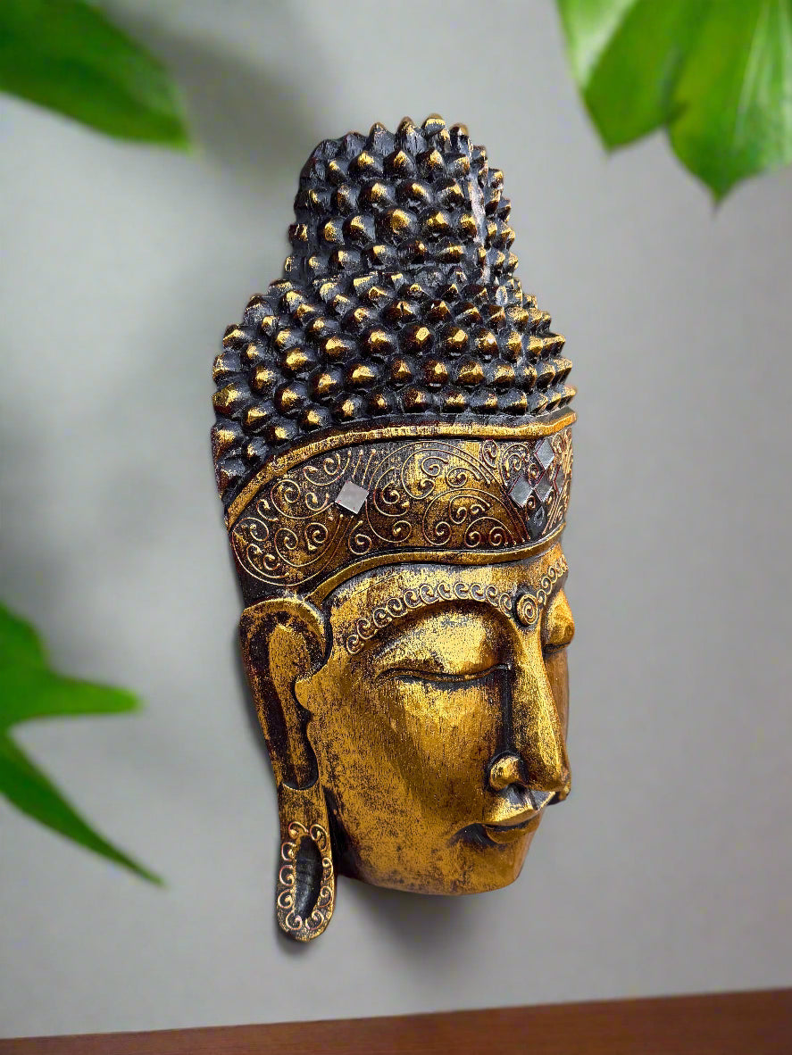 Gold Buddha head statue with ornate patterned headdress and closed eyes