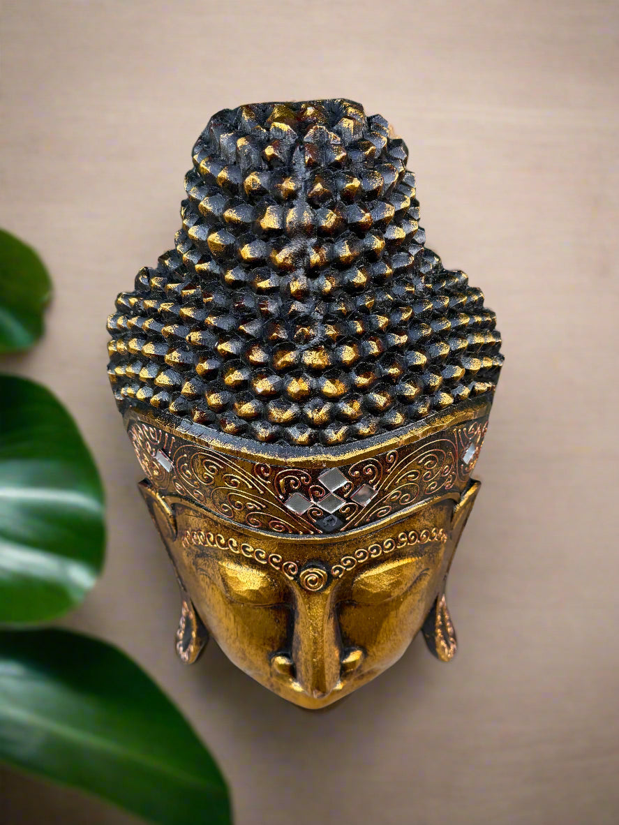 Gold Buddha head sculpture with ornate patterned crown and textured hair