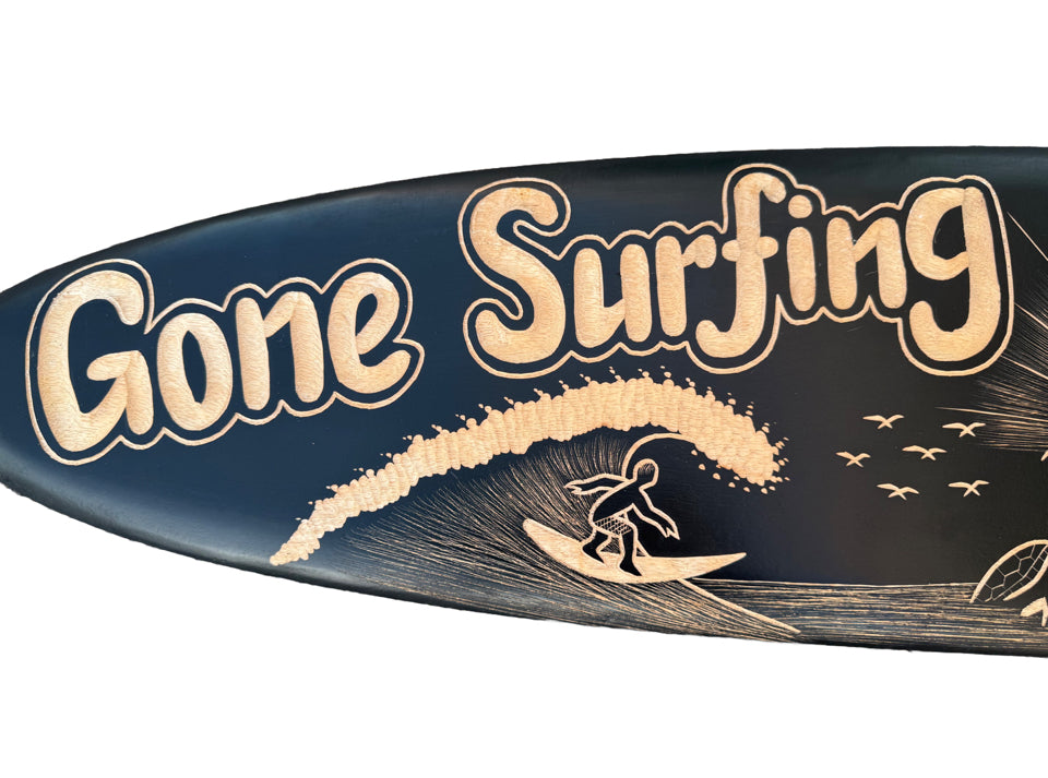 Surfer riding a wave on a dark blue surfboard with the text Gone Surfing.
