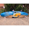 Painted surfboard with orange VW bus on a sandy beach, blue sky, flowers, and Gone to the Beach text.