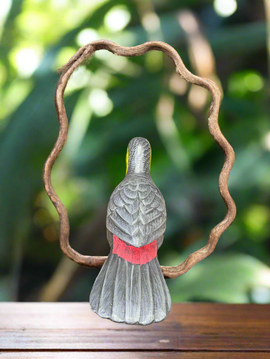 gray wooden bird statue with red neck band inside a twisted vine frame