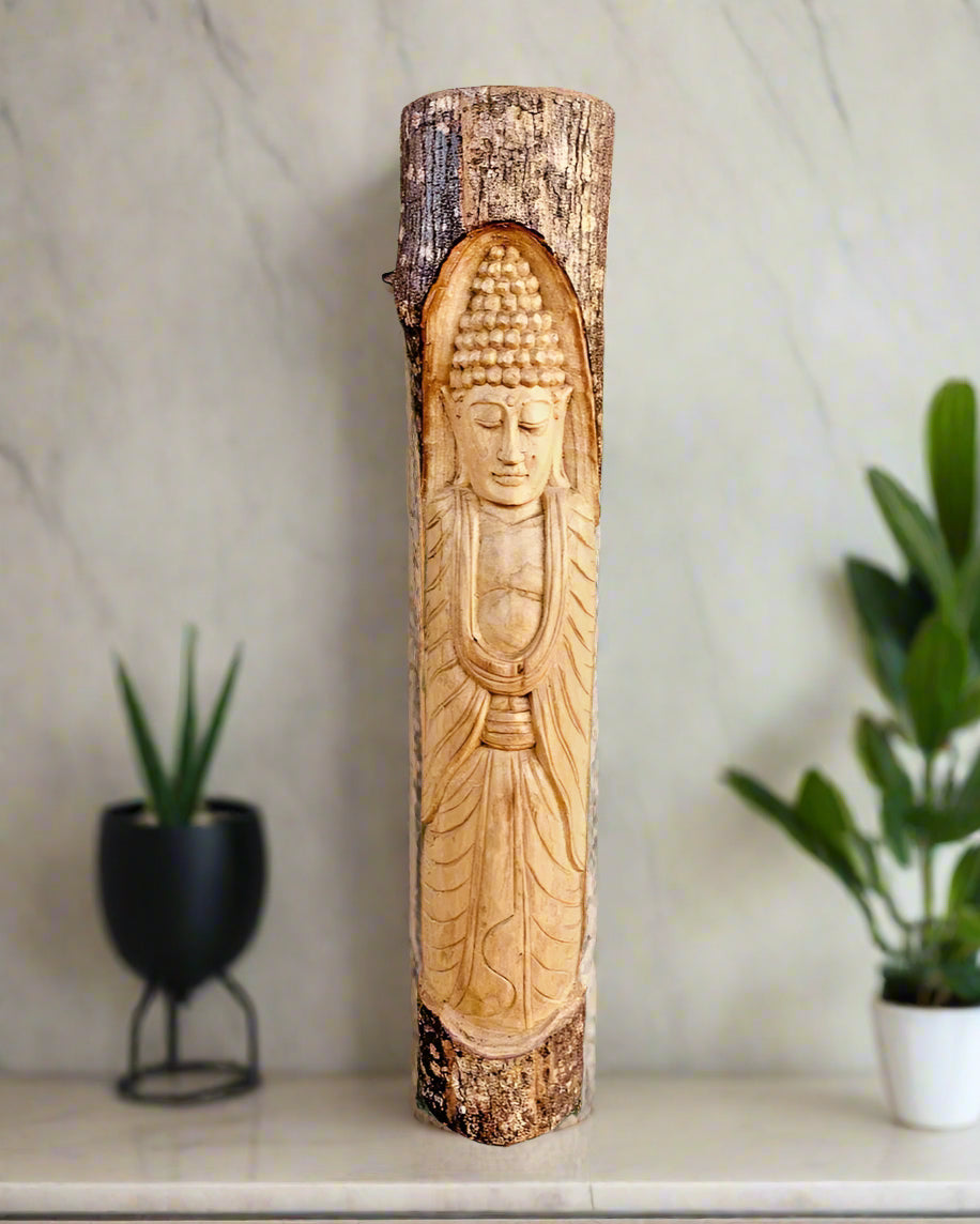 Carved Buddha statue on a wooden log pedestal indoors with plants in the background