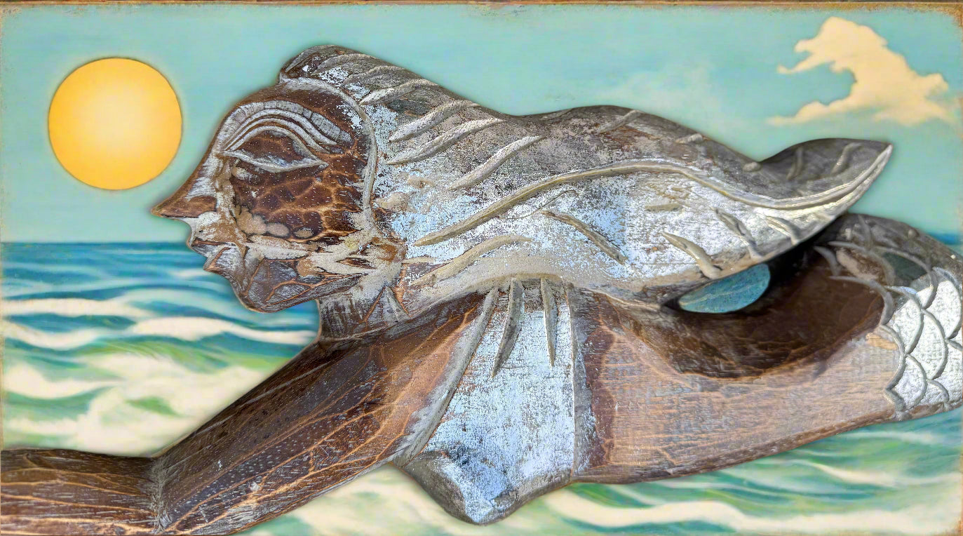 carved wooden fish sculpture with sea backdrop