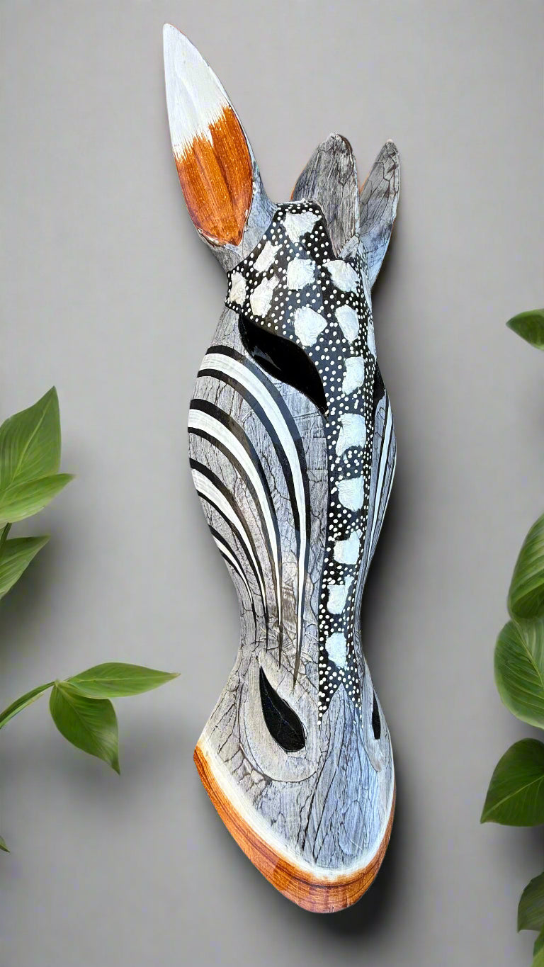 Decorative wooden fish sculpture with black-and-white patterns and orange-tipped fins