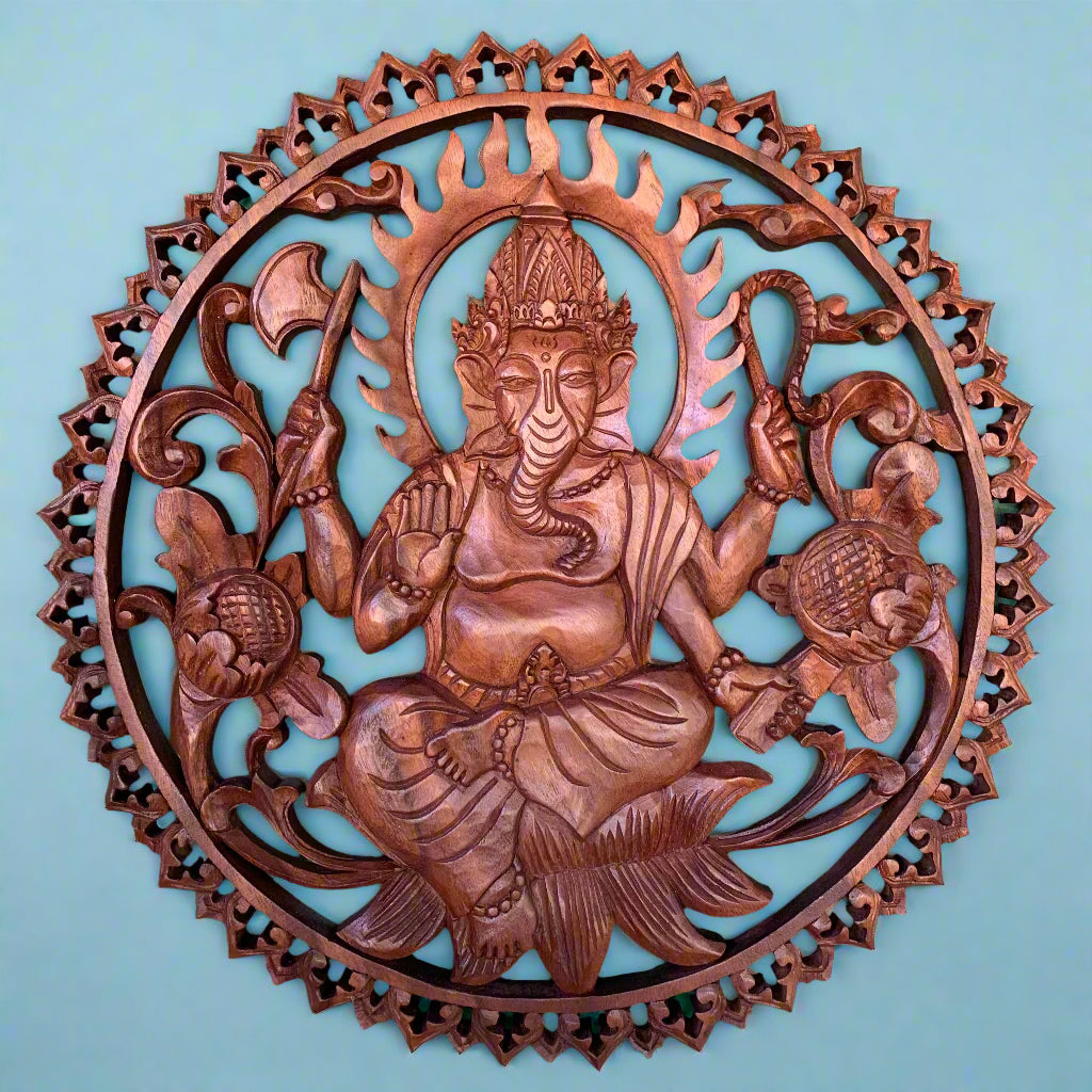 Round wooden carving of the Hindu deity Ganesha with multiple arms in a circular decorative frame.