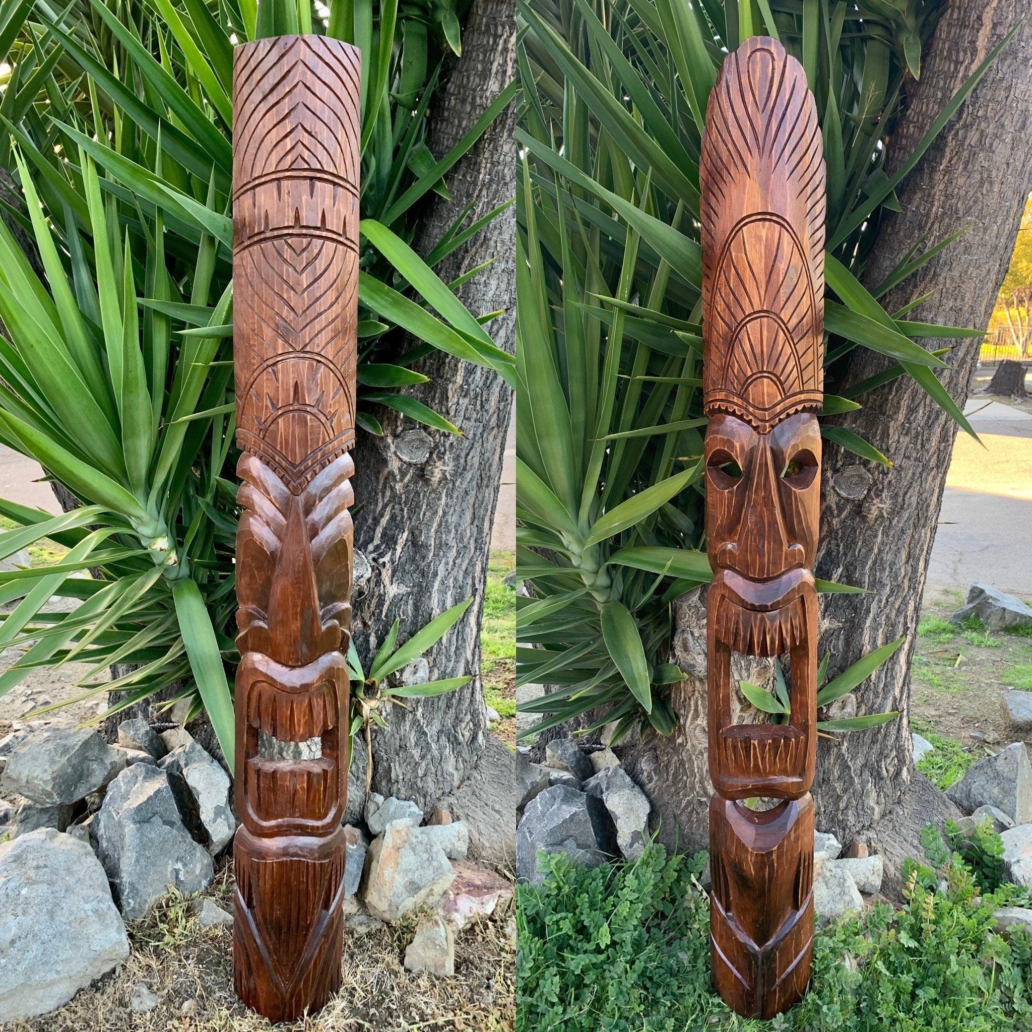 Wooden carved totem pole with tribal face and geometric patterns outdoors