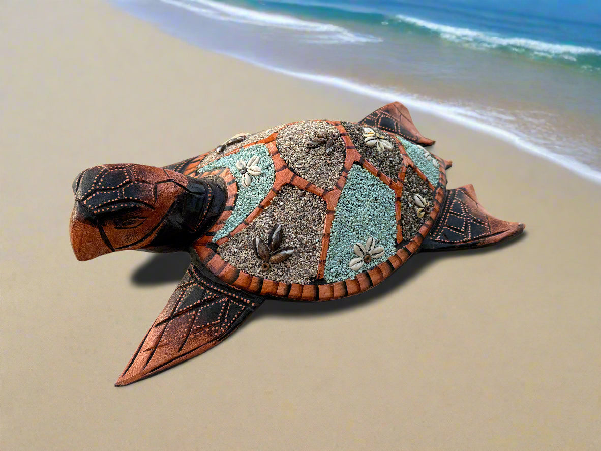 Decorative mosaic sea turtle sculpture on a sandy beach by the ocean