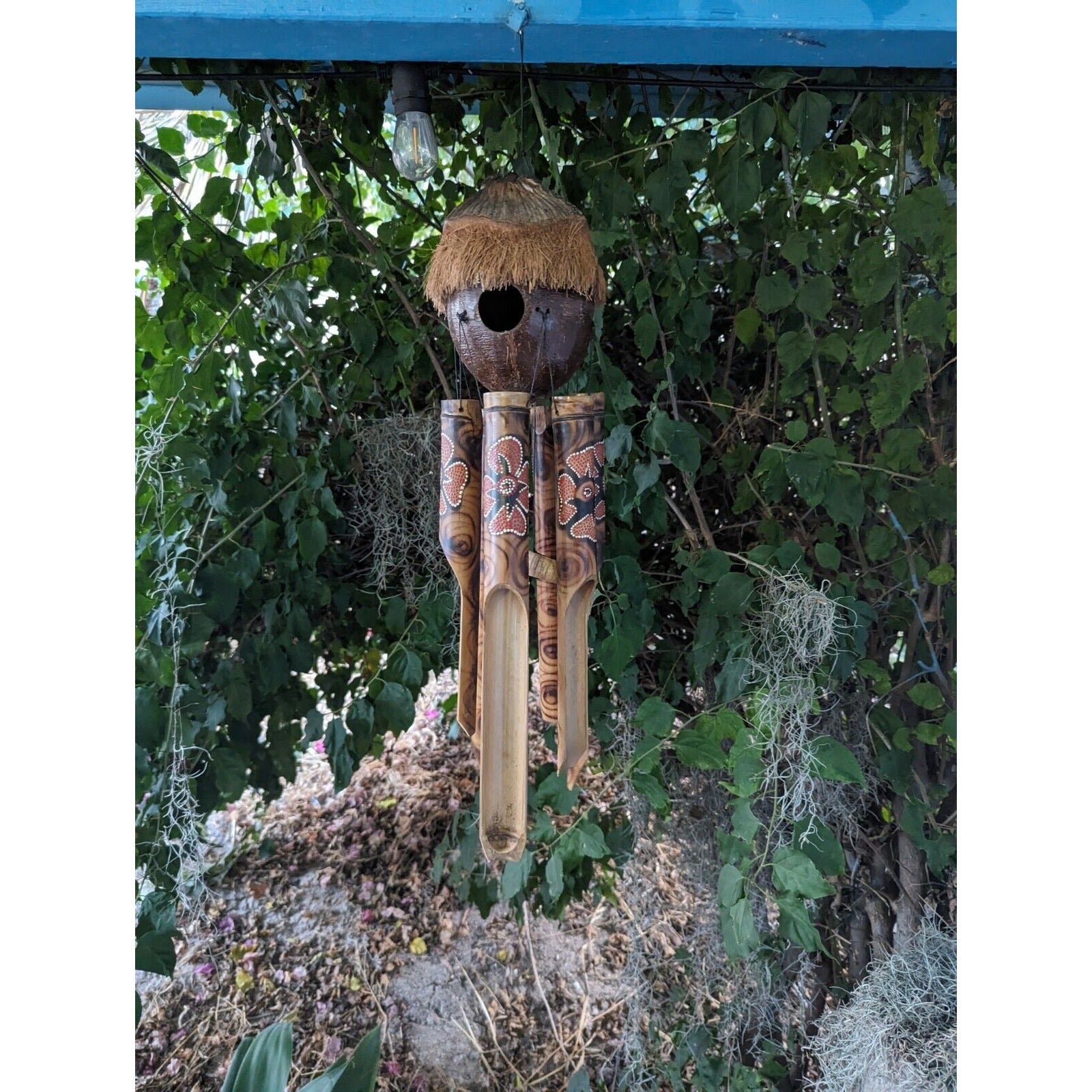 handmade bamboo wind chime with carved patterns hanging outdoors