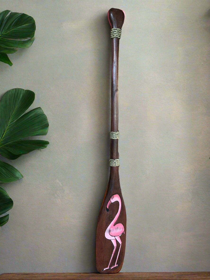 hand-painted flamingo on a tall wooden paddle with rope bindings