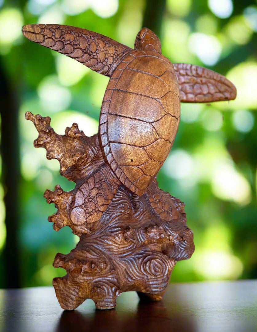 Hand-carved wooden turtle sculpture with a textured shell on a carved base