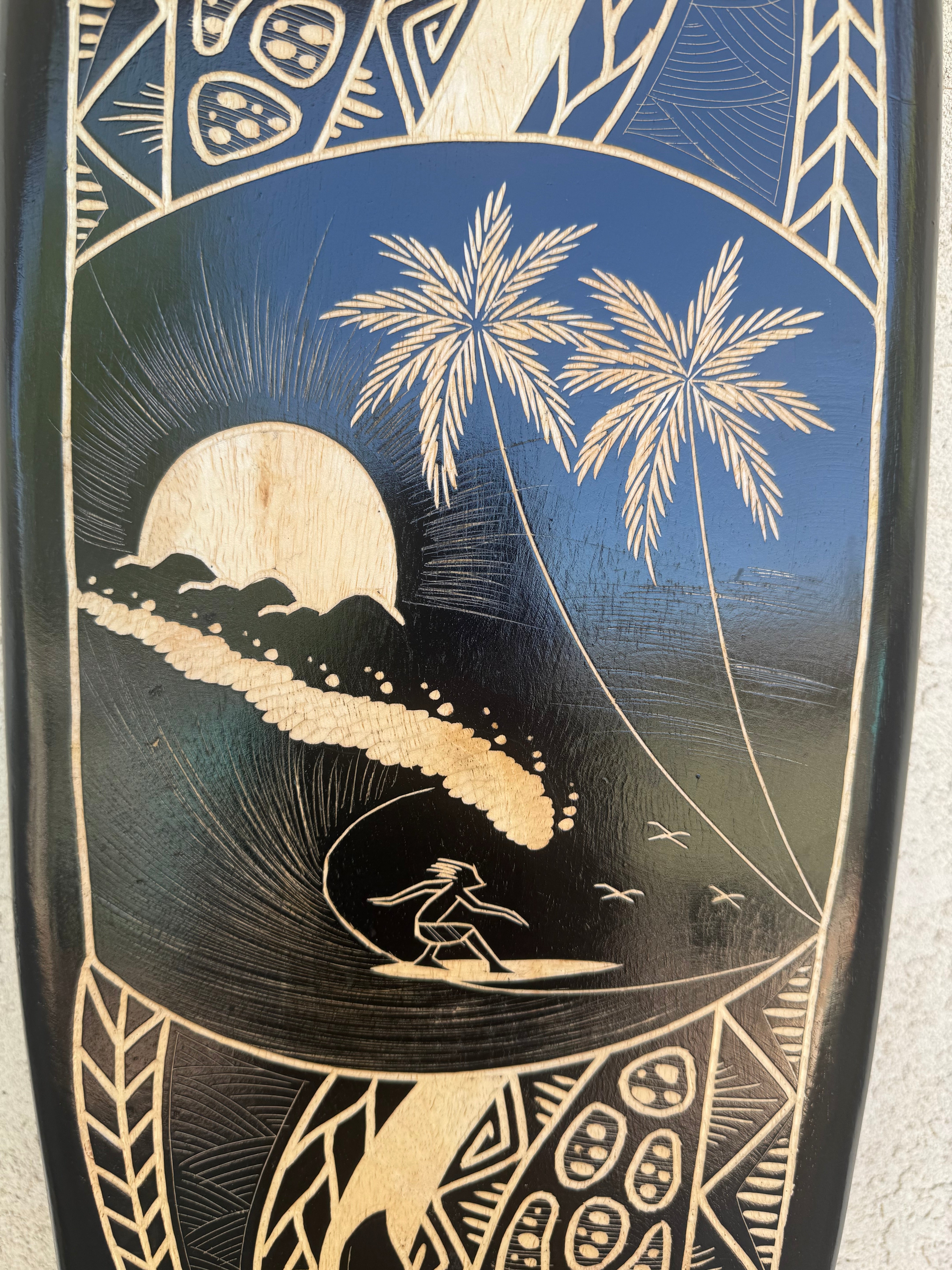 Wood-carved Hawaiian sunset with palm trees and a surfer on a wave.