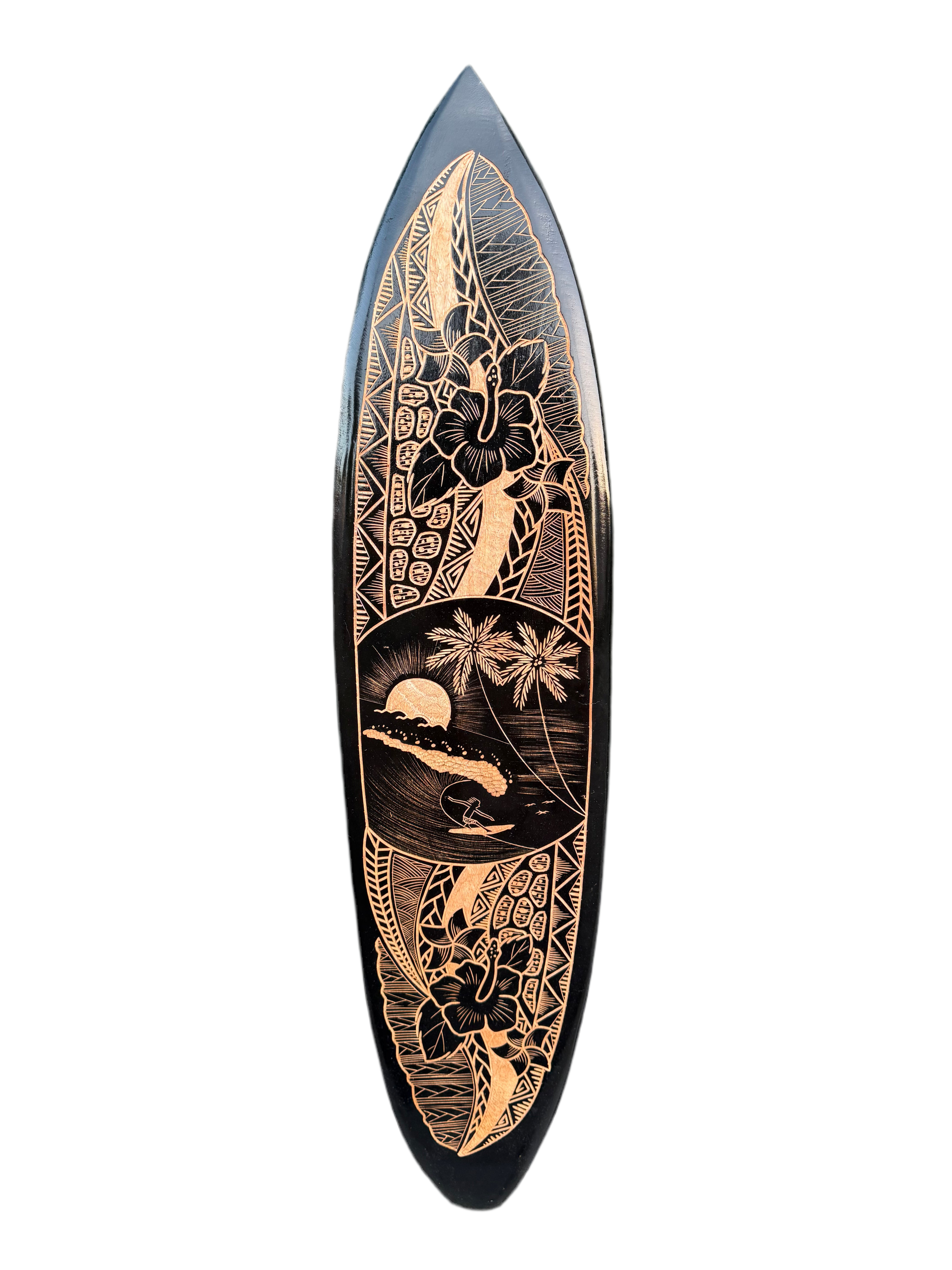 Copper-toned engravings on a black surfboard featuring hibiscus, palm trees, and a sunset scene