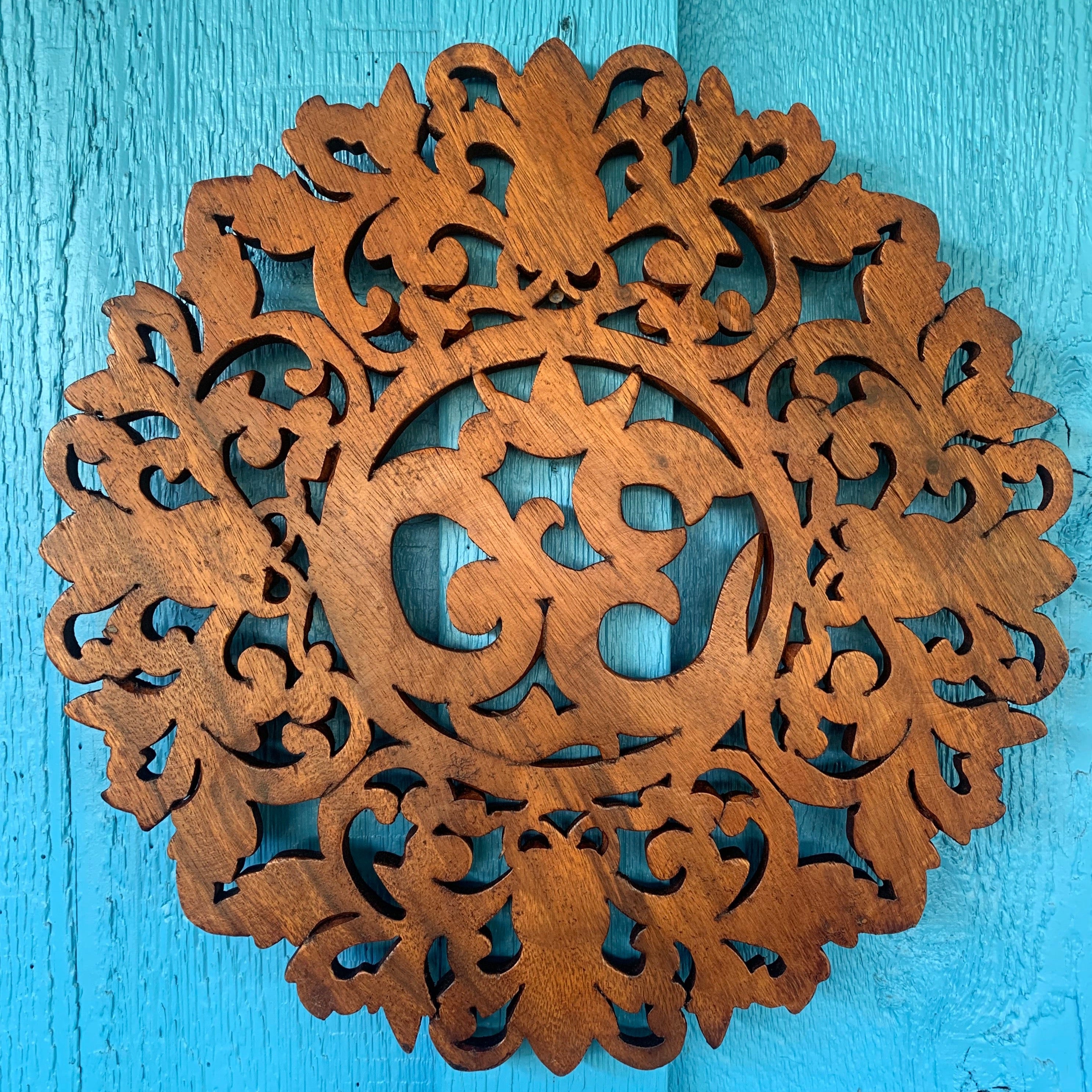 intricate wooden snowflake mandala cutout on teal blue wooden background