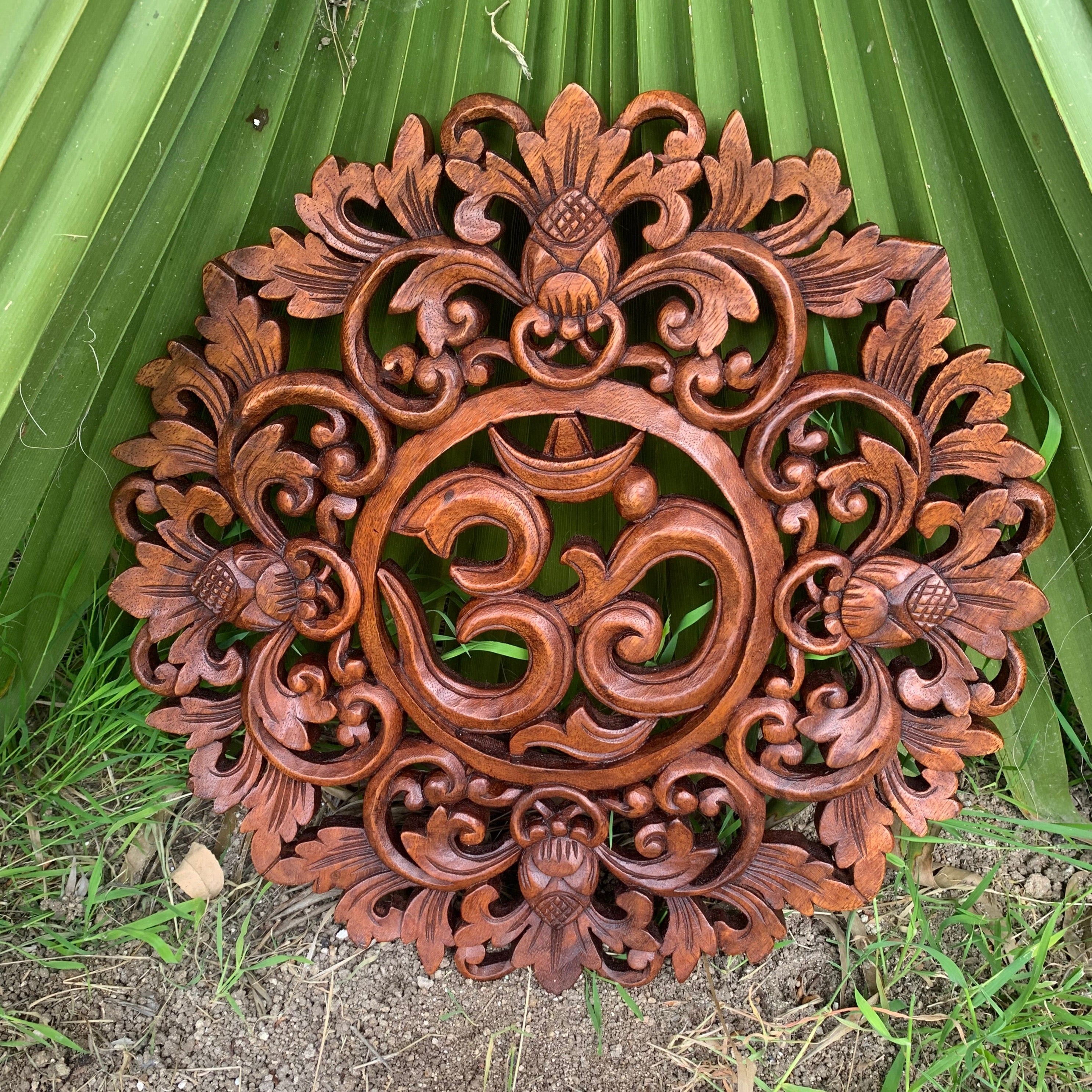 Intricately carved round wooden panel with floral scrollwork