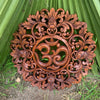 Intricately carved round wooden panel with floral scrollwork