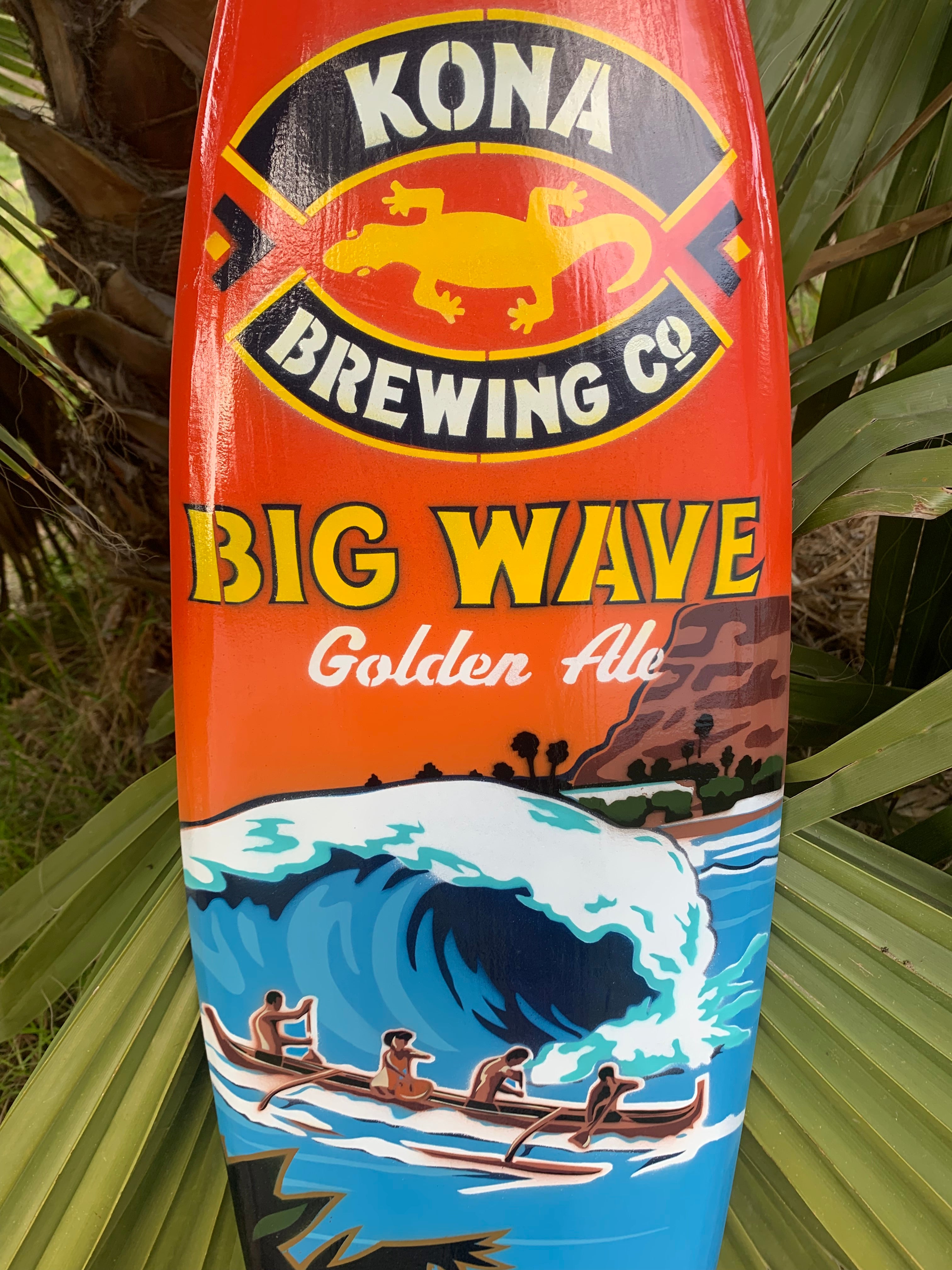 Kona Big Wave Golden Ale label with a large ocean wave and paddlers in a canoe