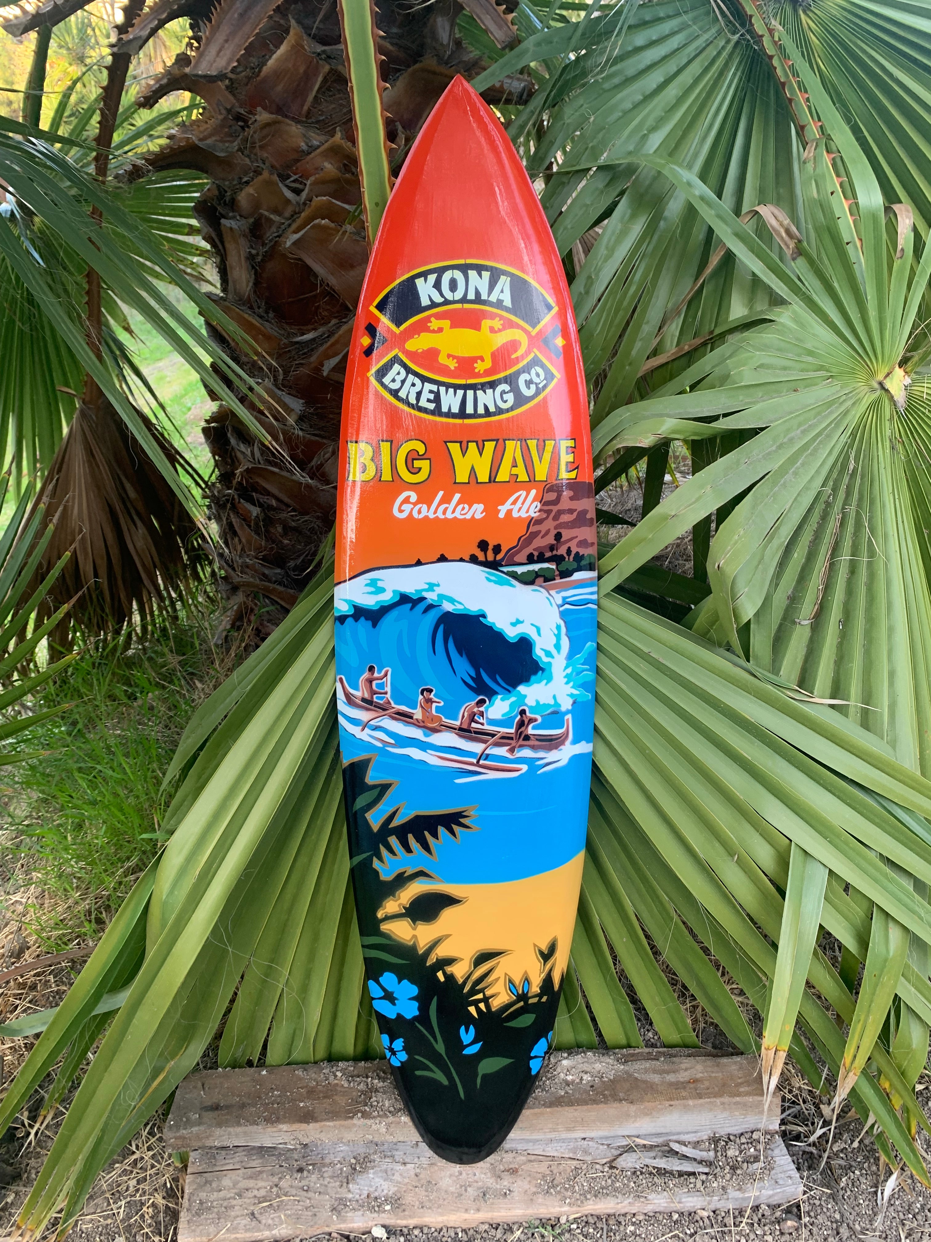 Colorful Kona Big Wave surfboard with palm-tree sunset and ocean wave design