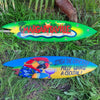 two colorful surfboards with Margaritaville and cocktail graphics resting in grass