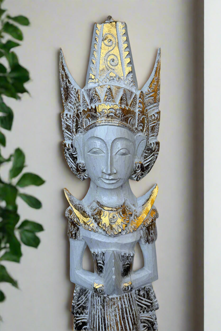 Decorative carved statue with a tall gold and silver crown