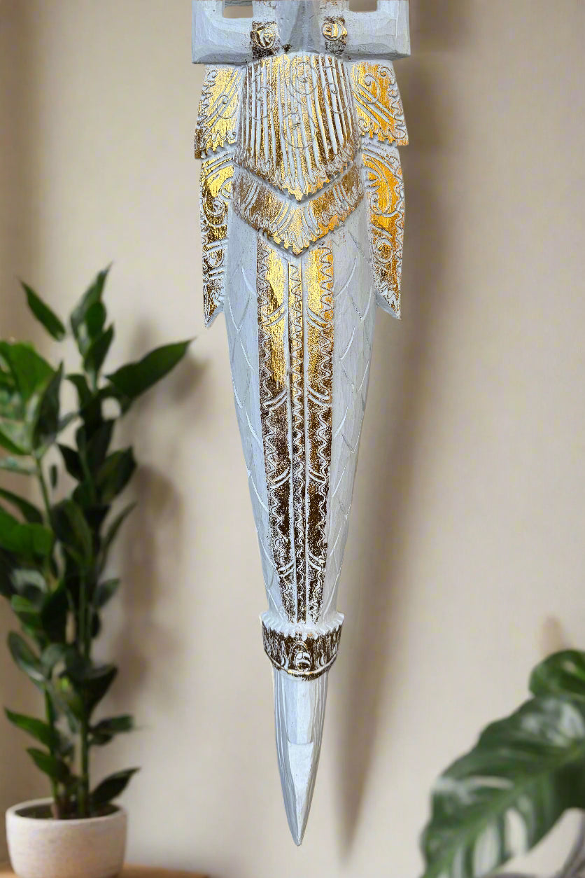 Ornate white and gold decorative dagger sculpture with intricate carvings.