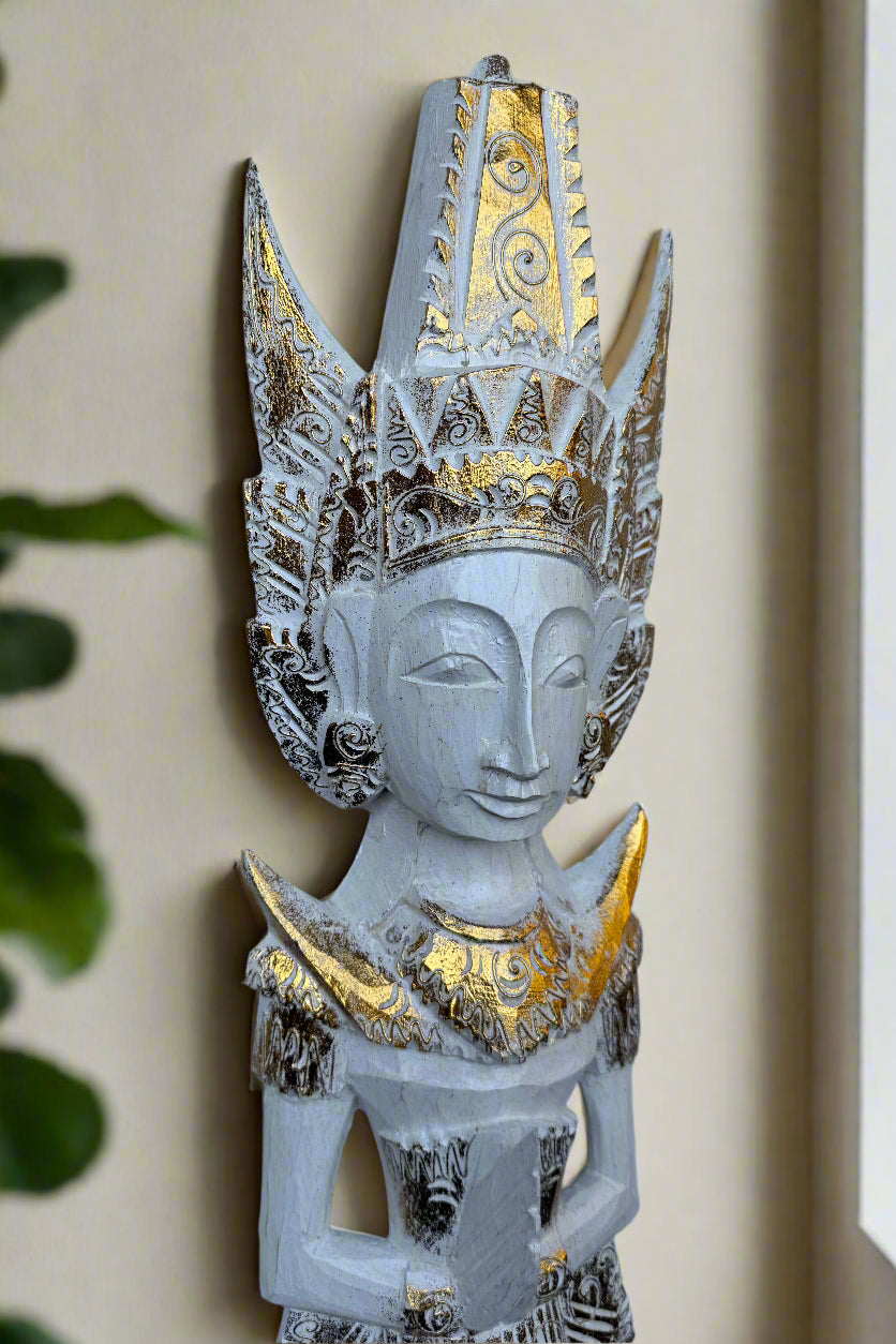 Wooden statue with ornate gilded crown and gold detailing, serene face.