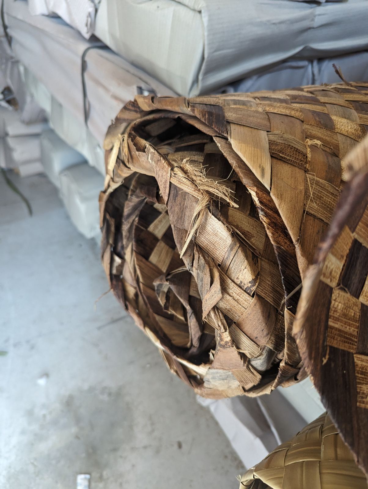 Close-up of a rolled palm-leaf woven mat
