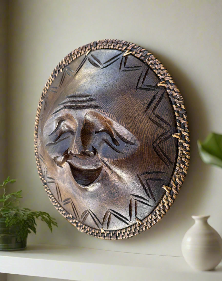 round wooden laughing mask with woven border on a shelf