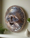 round wooden laughing mask with woven border on a shelf