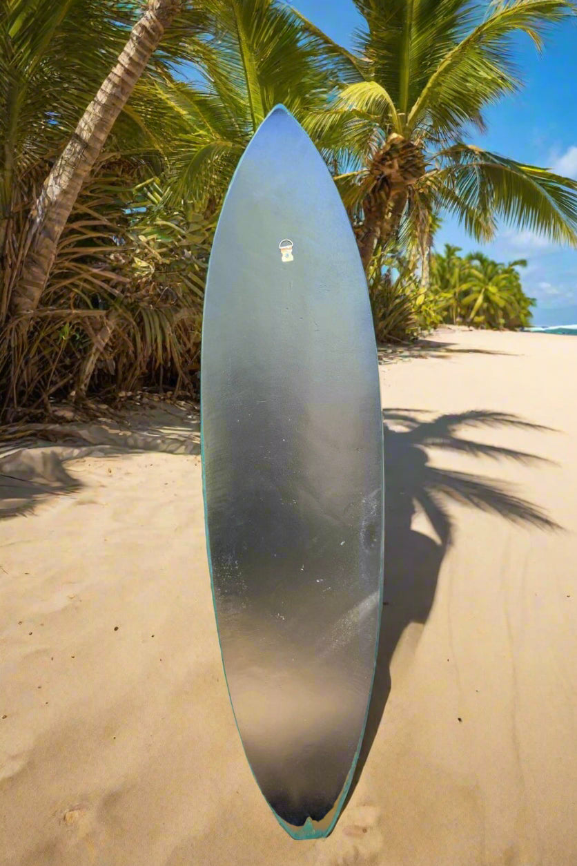 upright surfboard on a tropical beach with palm trees and blue sky