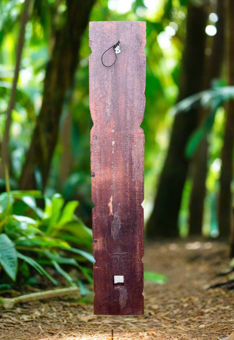 tall wooden post with a small metal loop on top in a lush forest path