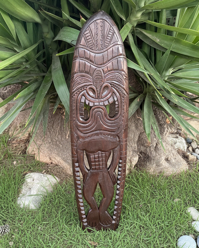 tribal tiki carved into a surfboard