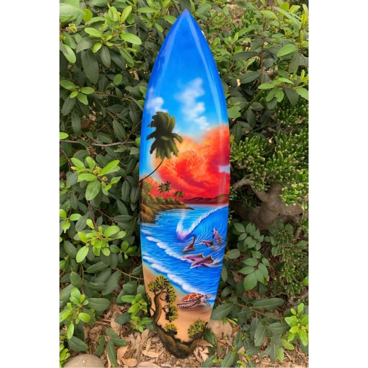 Colorful surfboard with tropical beach scene and palm trees