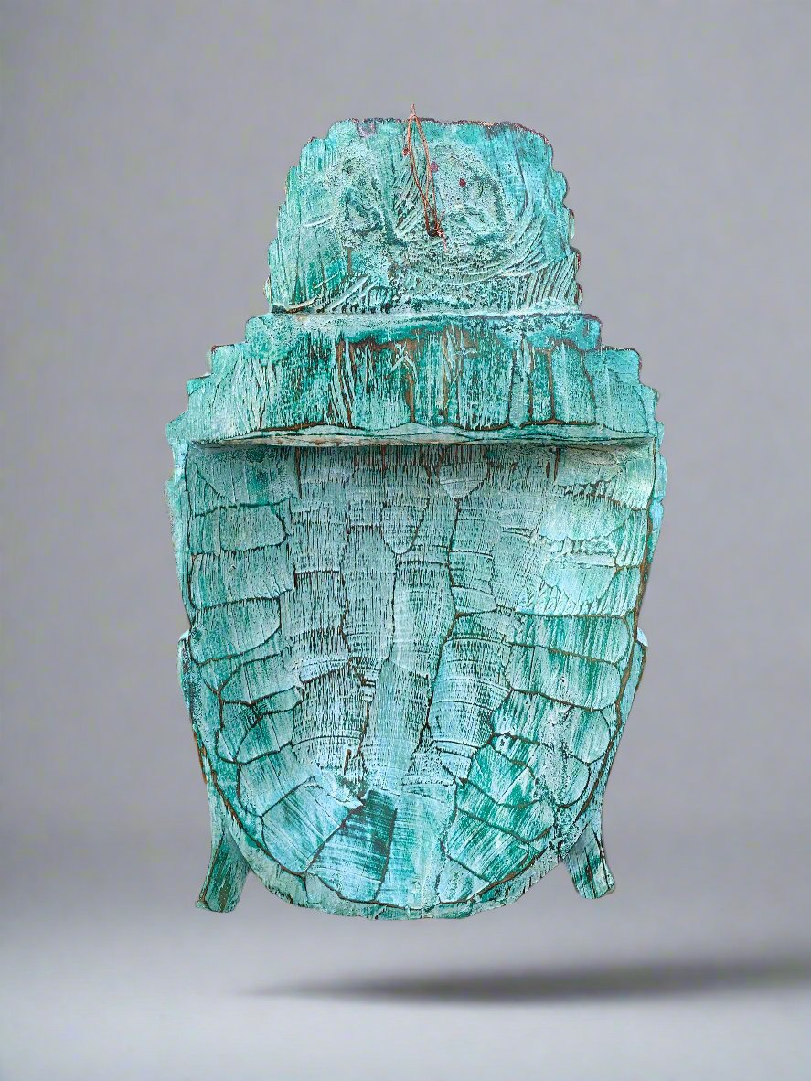 turquoise cracked wooden statue with a tiered top