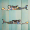 Two mermaids reaching for stars on a teal wood panel wall, whimsical sea-inspired wall art.