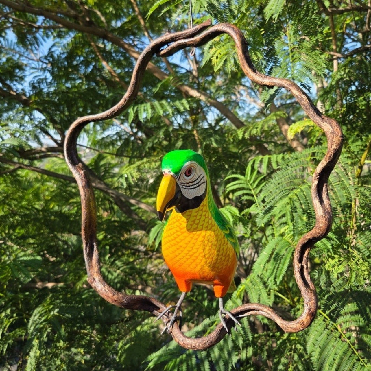 Colorful green parrot perched on a branch with a natural green background
