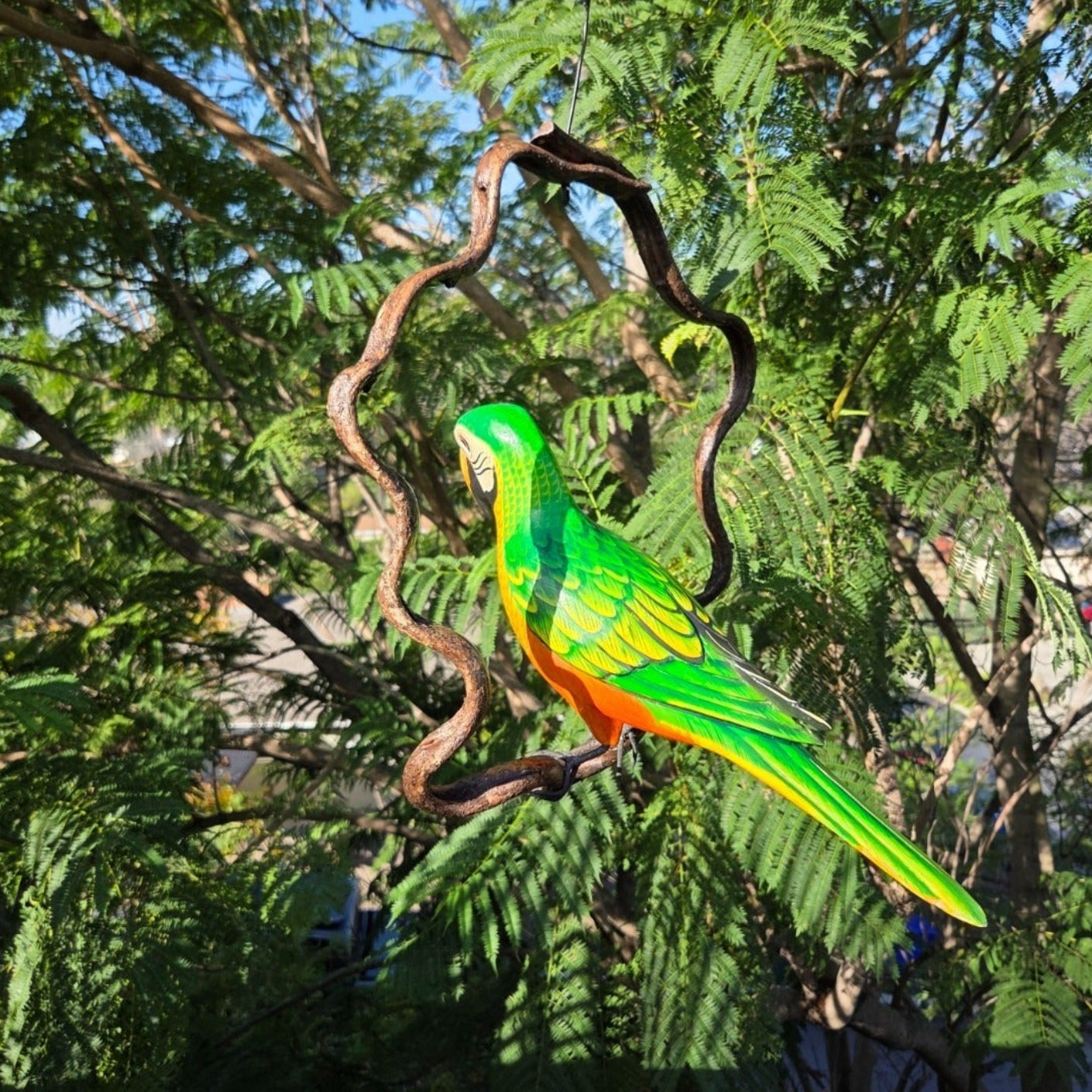 Colorful parrot perched on a branch with a natural green background