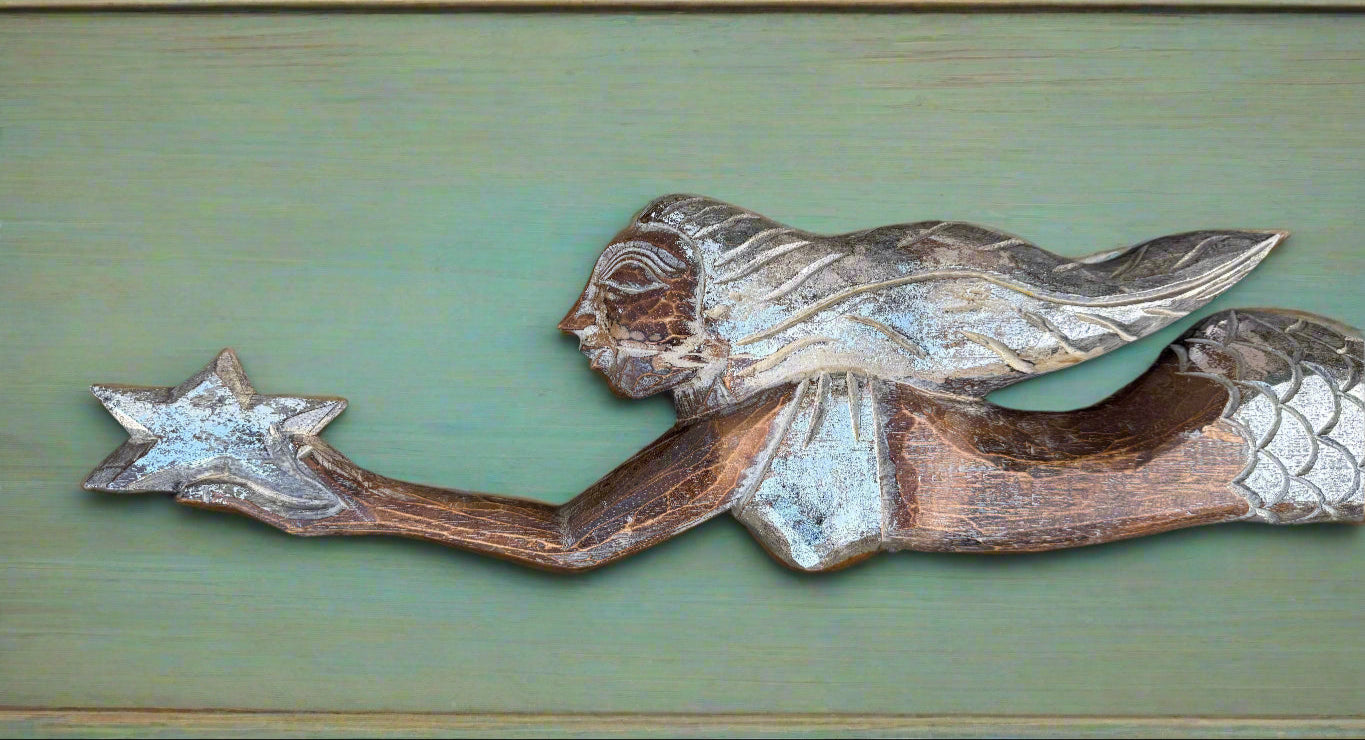 Weathered wooden mermaid reaching for a star carving.