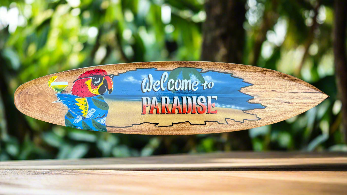 Wooden surfboard sign with colorful parrot and the words Welcome to Paradise
