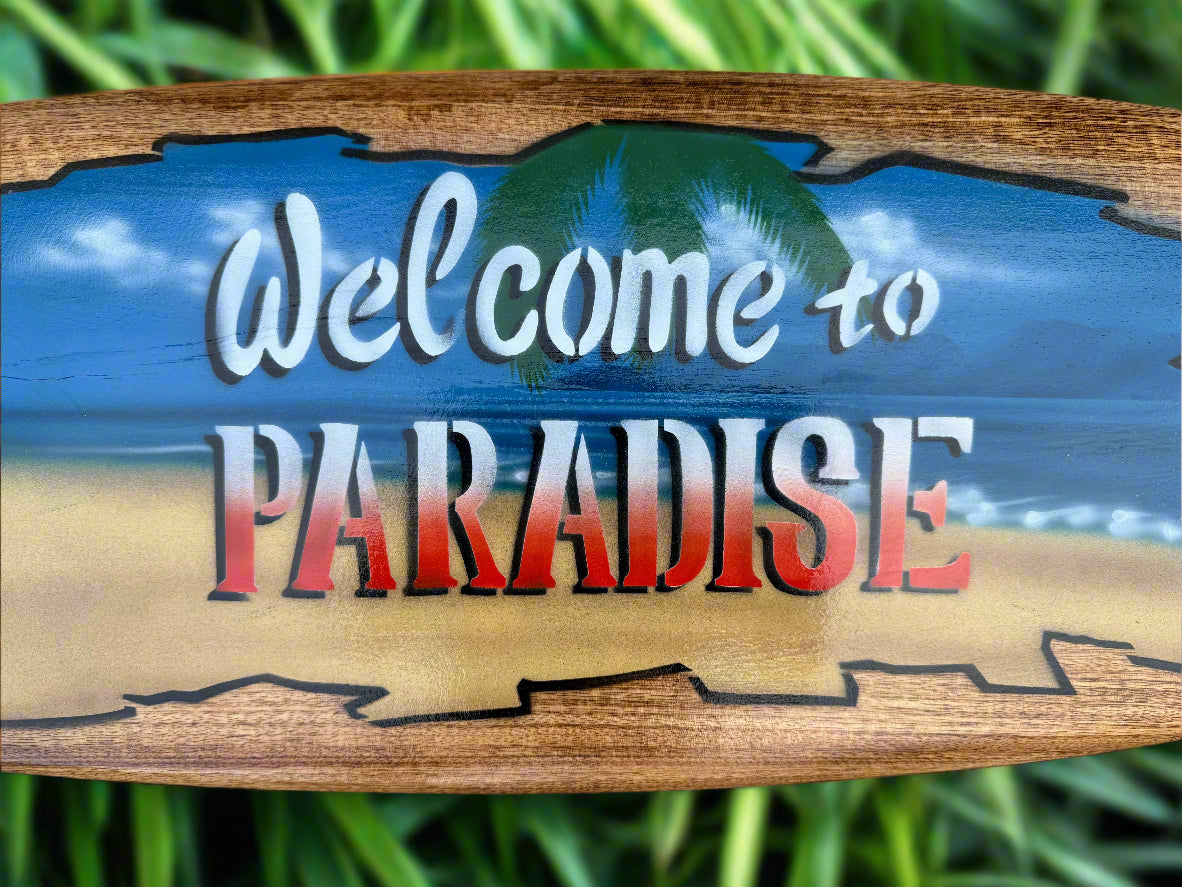 Wooden sign reading 'Welcome to Paradise' over a sandy beach and blue ocean