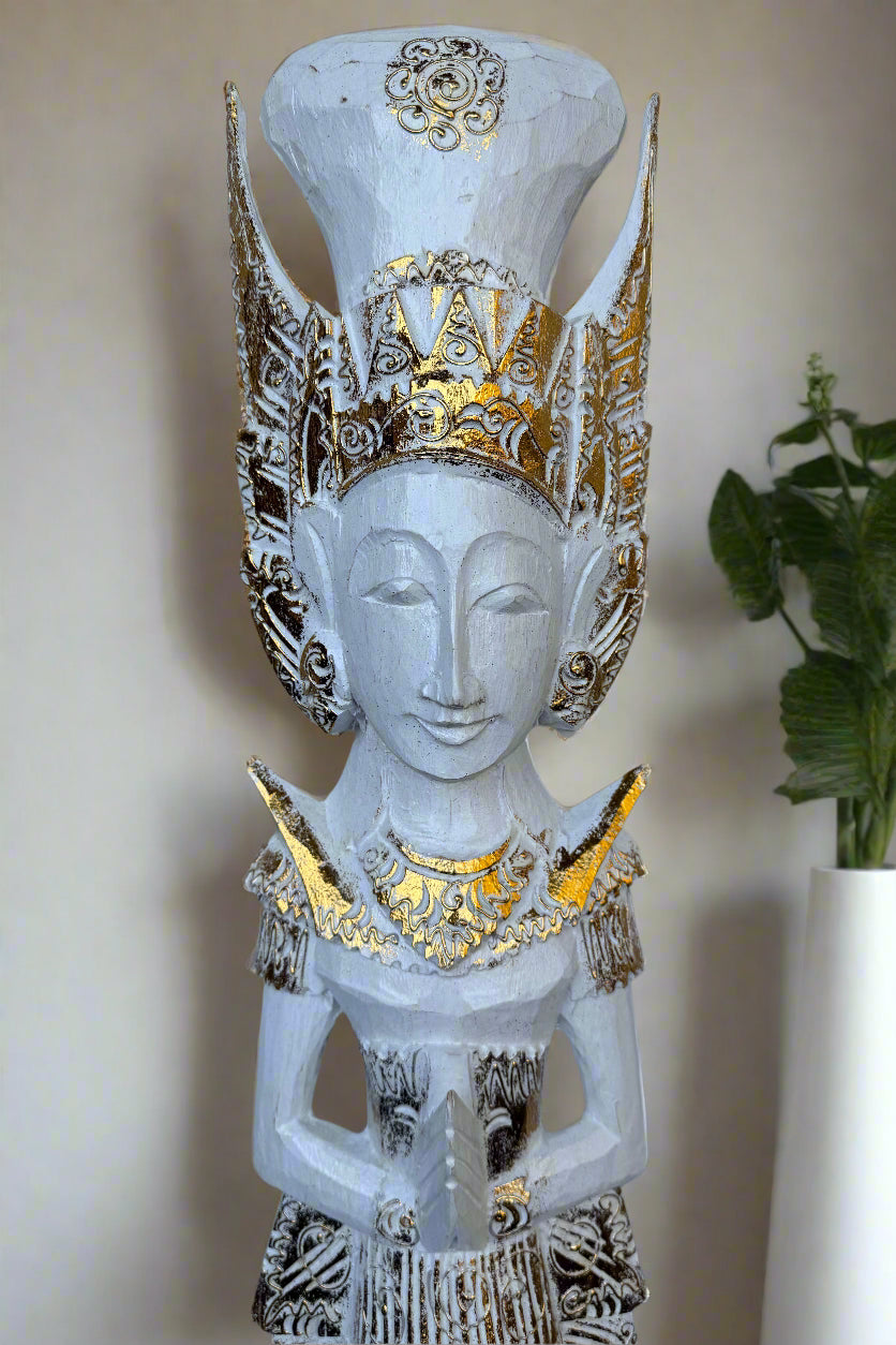 White carved statue with a gold ornate crown and praying hands