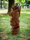 Wooden statue of a chubby child with angel wings in a park