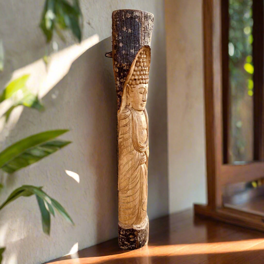 Carved wooden Buddha statue on a vertical post indoors