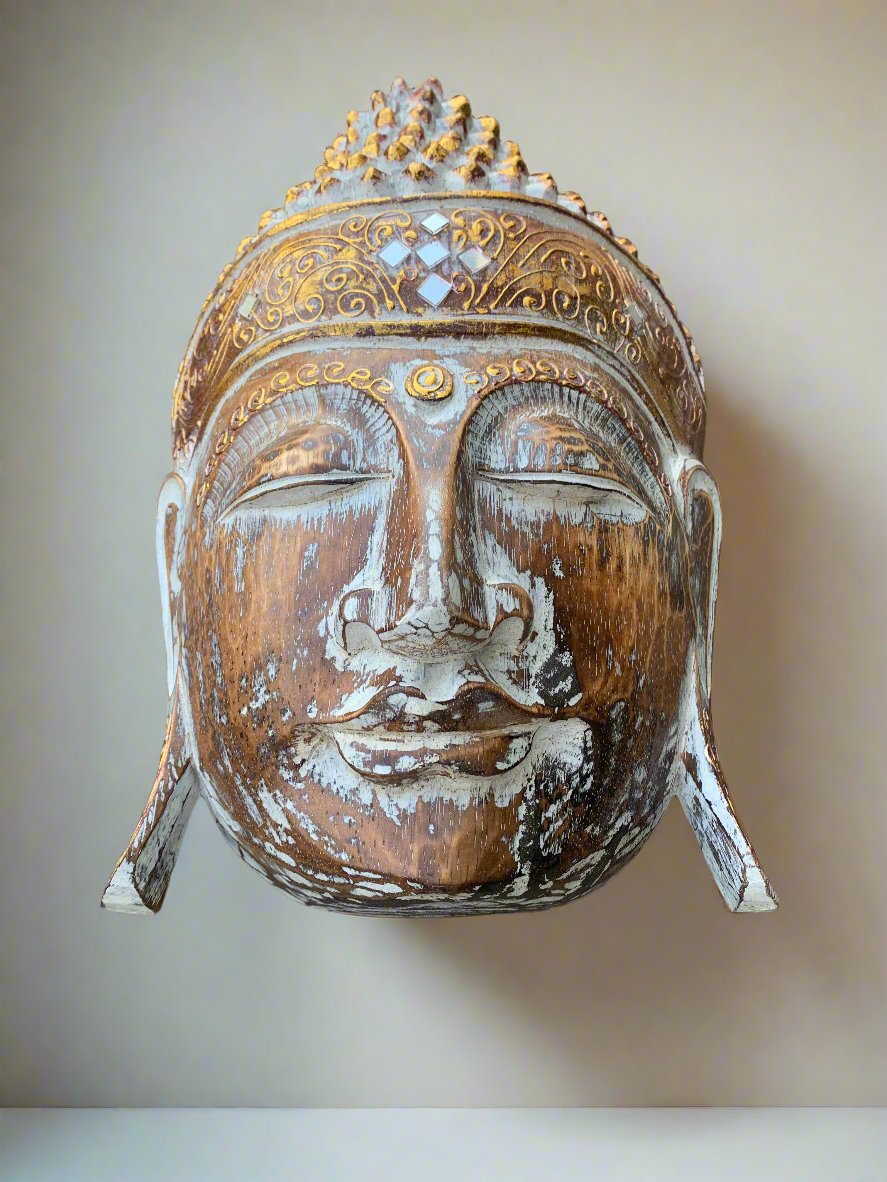 Wooden Buddha head statue with ornate crown and weathered paint.