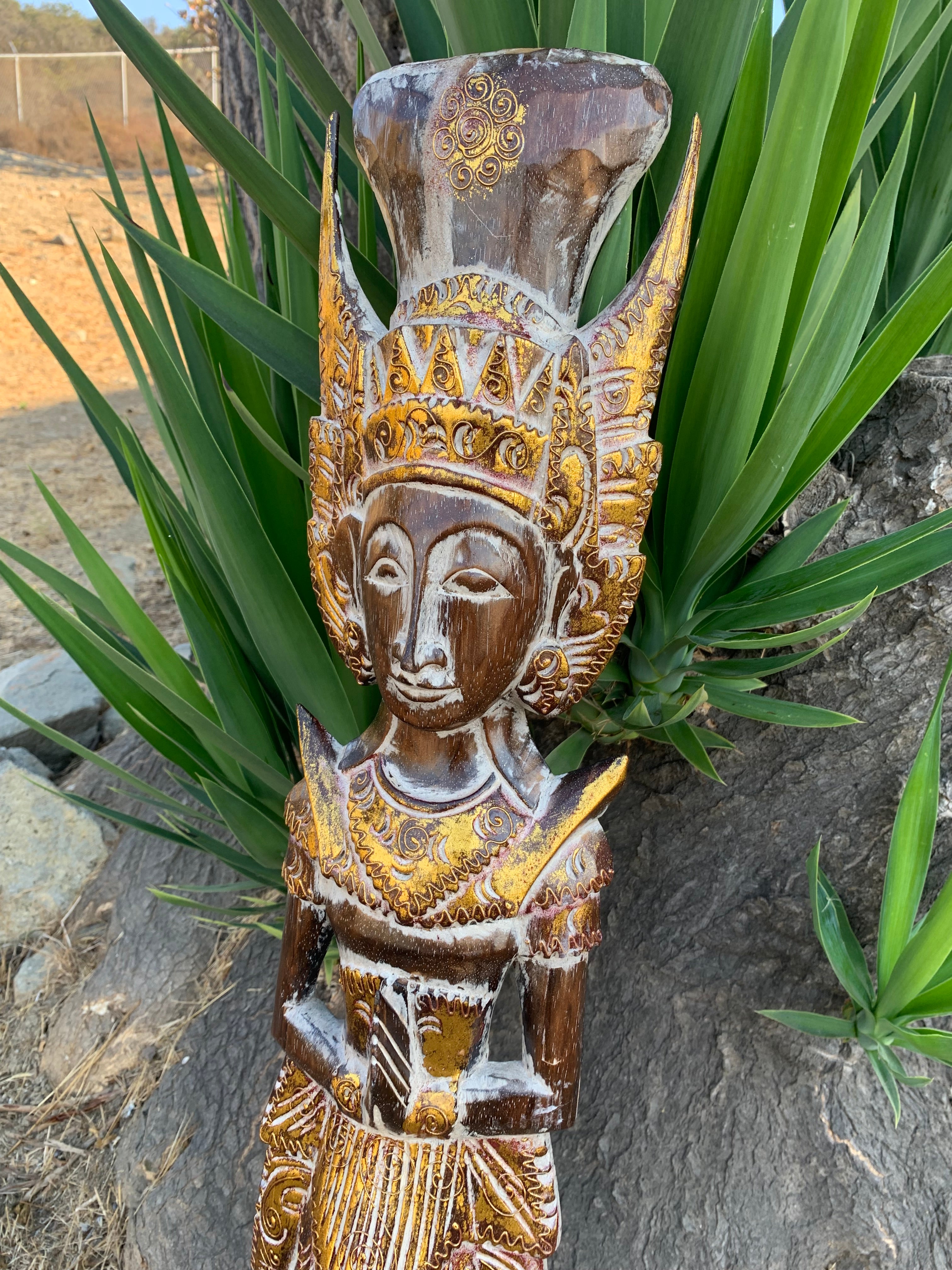 Wooden carved statue with ornate gold headdress and decorative patterns