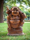 Wooden Laughing Buddha statue in a sunny park setting