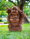 wooden laughing Buddha statue outdoors in a green park