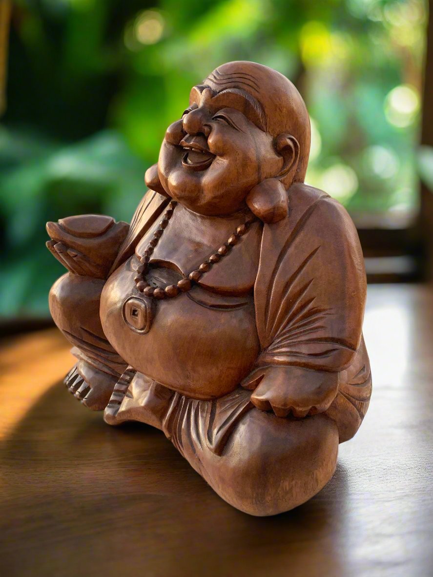 Wooden Laughing Buddha statue with beaded necklace on a wooden surface