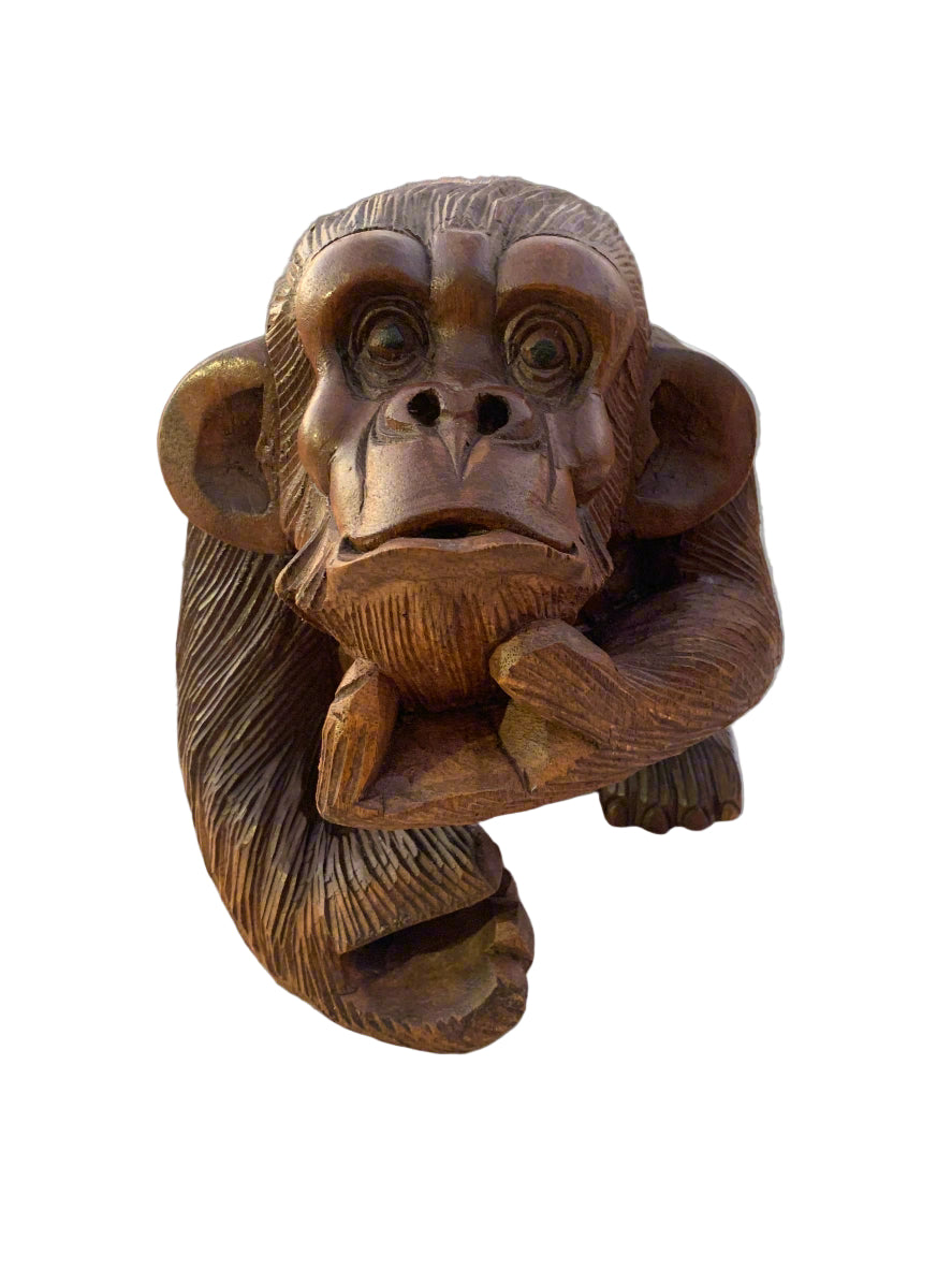 Wooden carved monkey figurine with textured fur and a thoughtful pose
