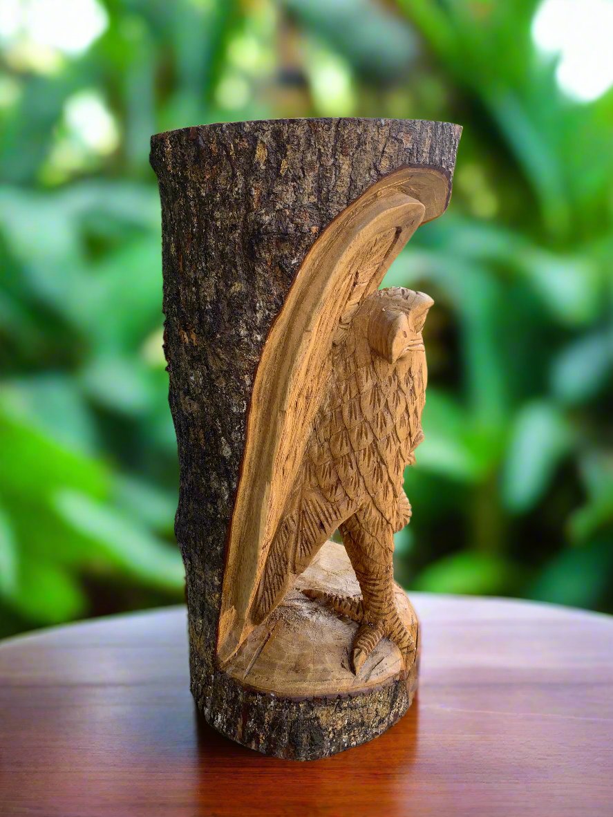 carved wooden owl sculpture on a tree stump with a blurred green garden background