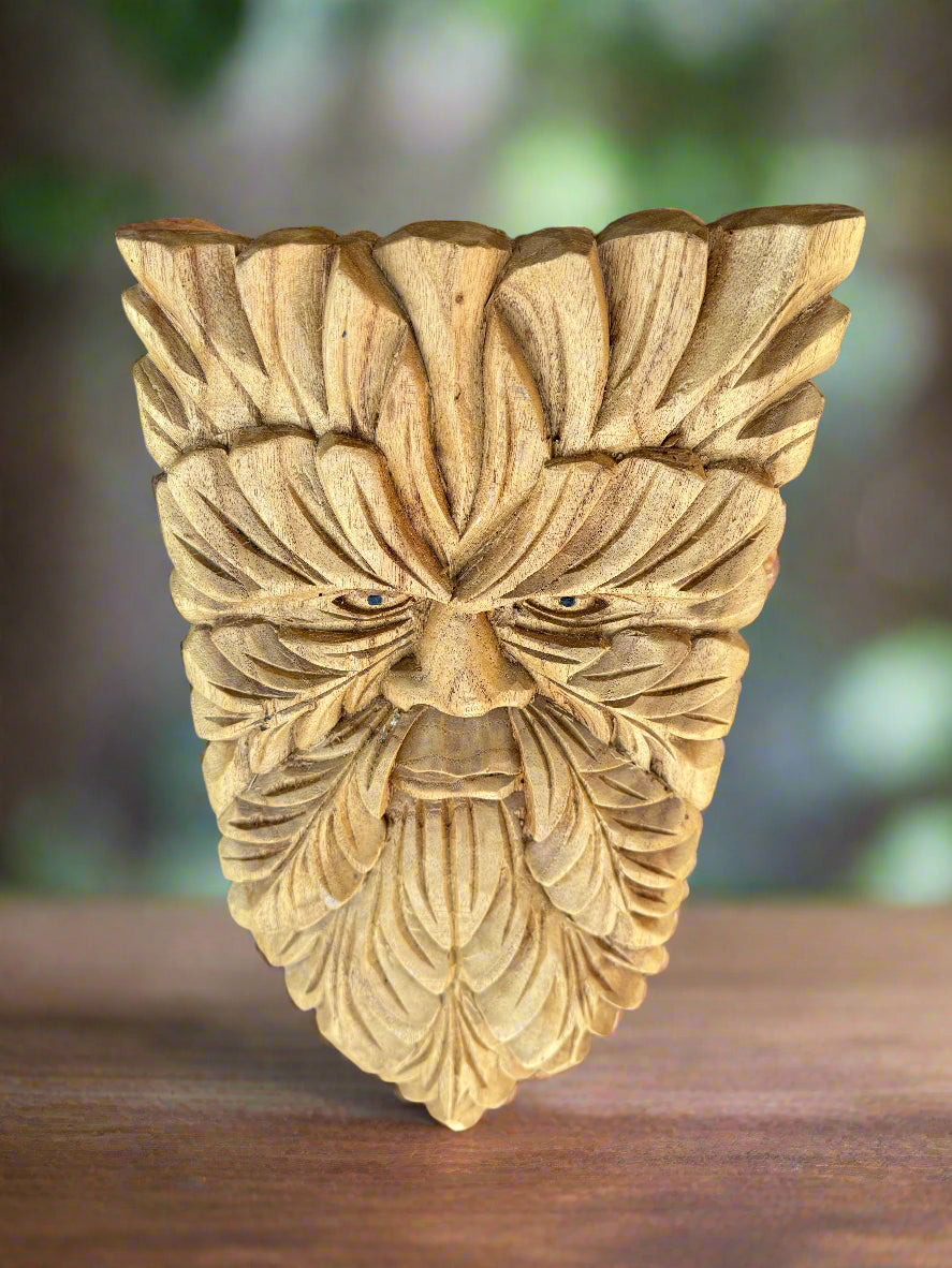 Carved wooden tiki face with leaf-patterned detailing